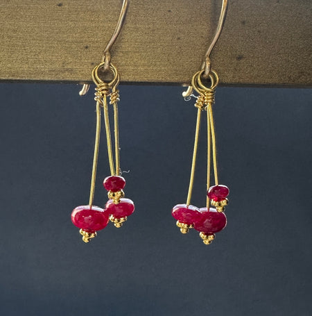 Twinkle Earrings with Burmese Rubies hanging on metal rack